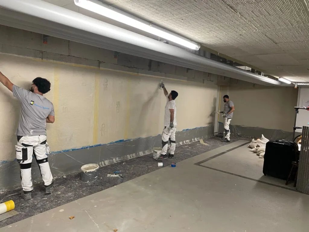 EOS-Team bei Putz- und Dämmarbeiten in einer Tiefgarage