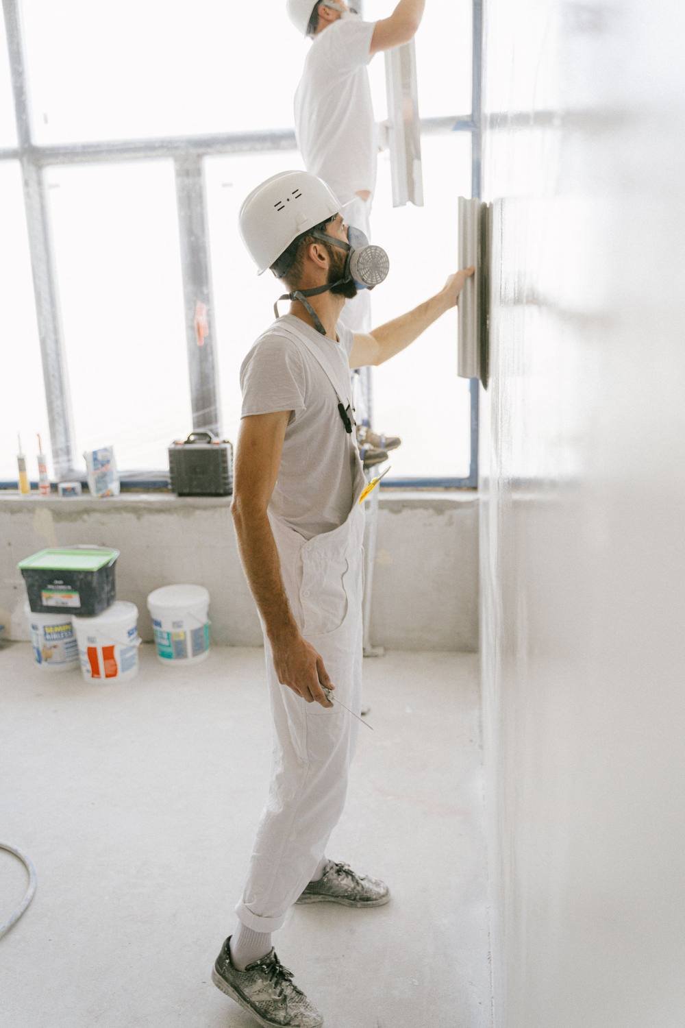 Handwerker verputzt eine Innenwand in einem hellen Raum